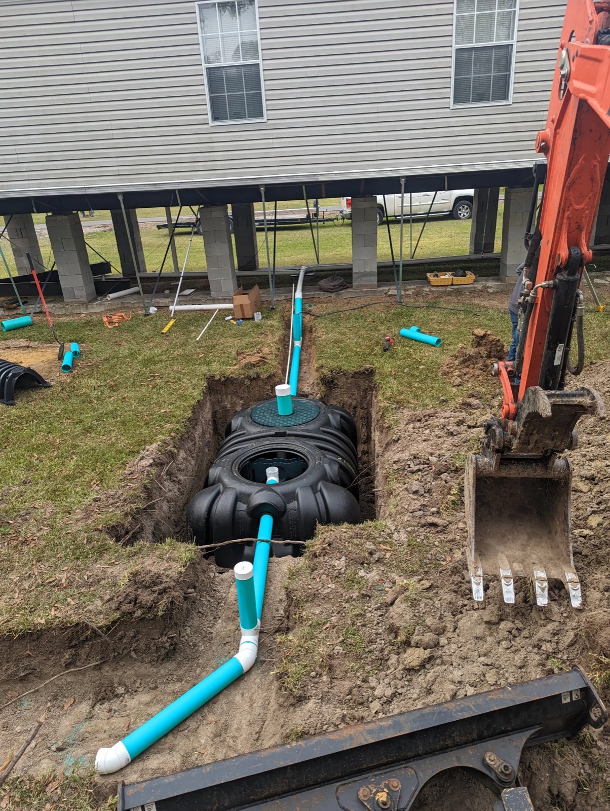 A MO-DAD treatment tank set beside a raised mobile home.