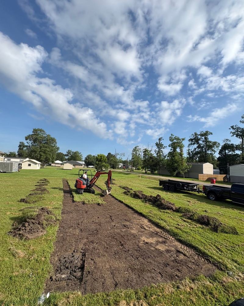 The crew laying a run of drainfield chambers with the excavator alongside.