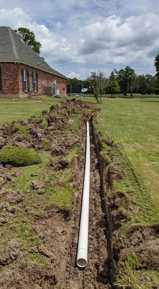 A service trench run across the lawn of a brick home.