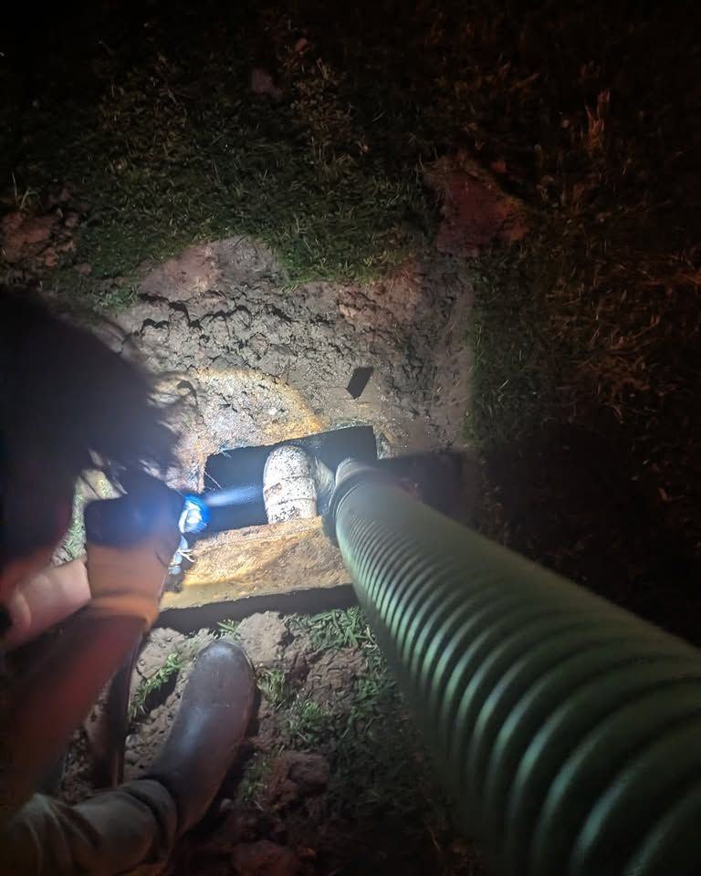 A crew member lighting up an open line to see what is inside it.
