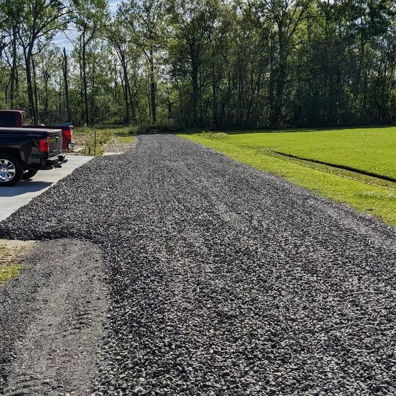 A finished gravel driveway running back to the treeline.