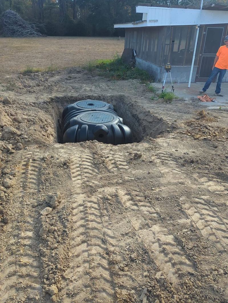 A tank lid set flush in a yard after backfilling.