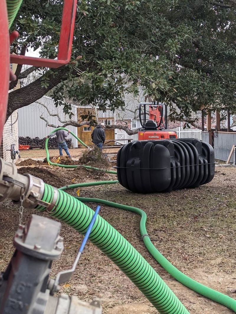A green suction hose and blue pipe running into an open treatment tank.